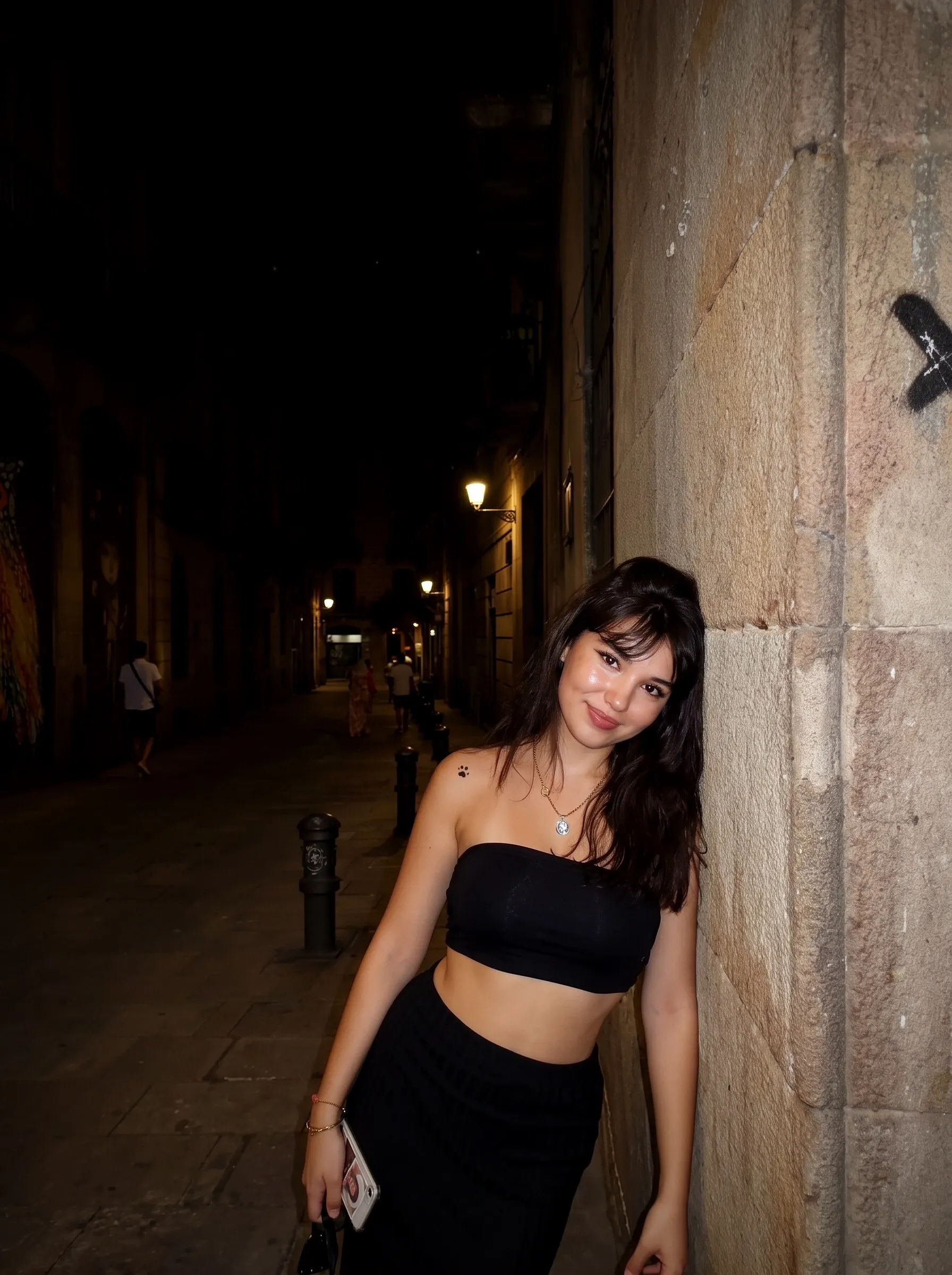 Night Flash look: the same street at night, the woman lit by a harsh direct flash, the alley dark behind her